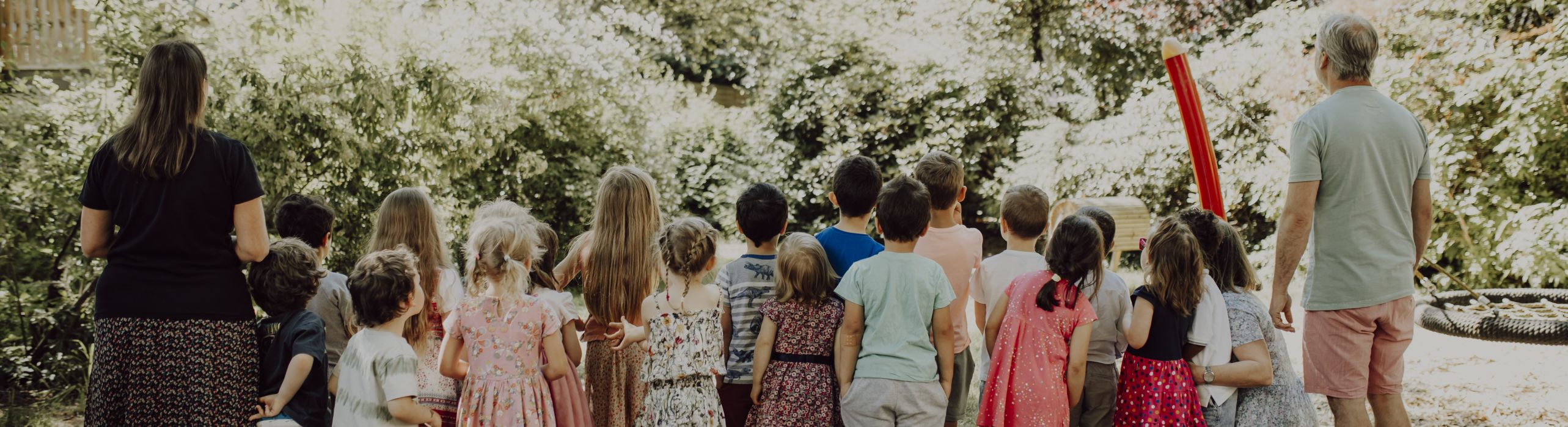 KITA Kinder und Erzieher von hinten